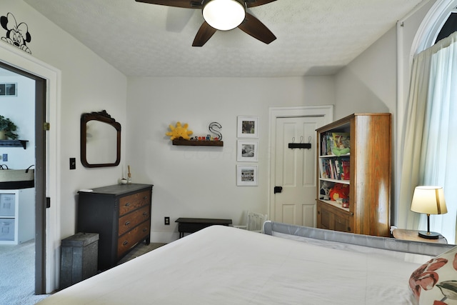 carpeted bedroom with a ceiling fan, a textured ceiling, and visible vents