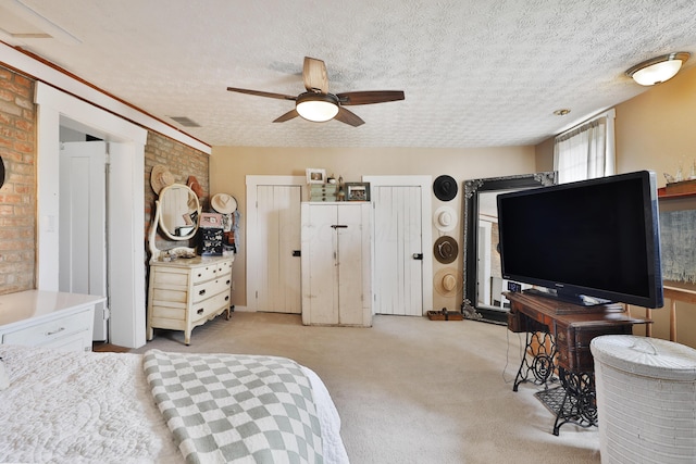 bedroom with visible vents, a ceiling fan, a textured ceiling, and light colored carpet