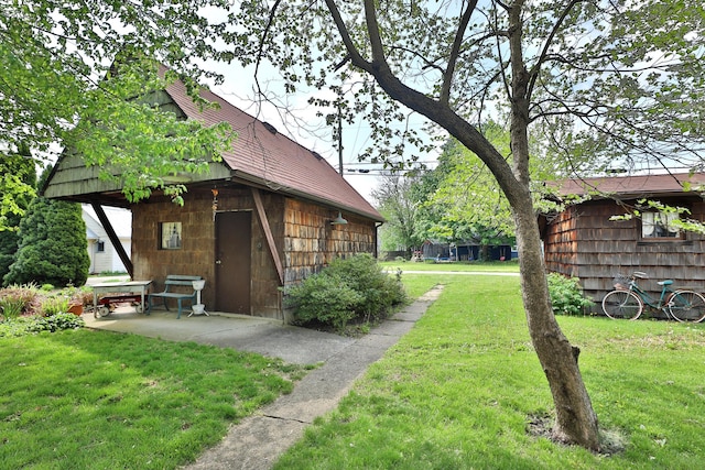 view of yard featuring an outdoor structure and a patio area
