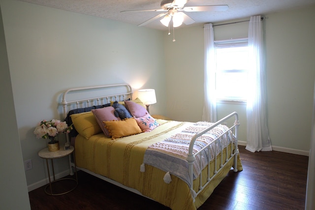 bedroom featuring baseboards, a ceiling fan, a textured ceiling, and wood finished floors