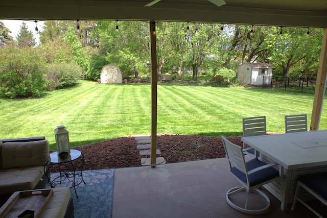 view of yard featuring a storage unit, an outdoor structure, a patio area, and fence