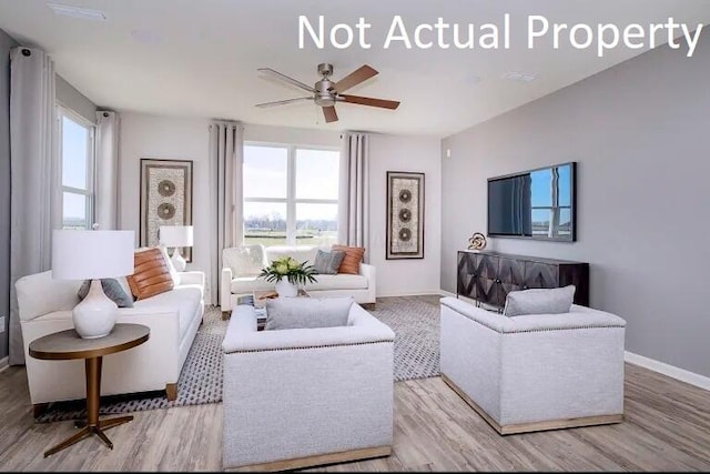 living area featuring baseboards, plenty of natural light, ceiling fan, and wood finished floors