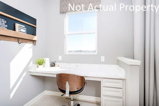 home office with baseboards and built in desk