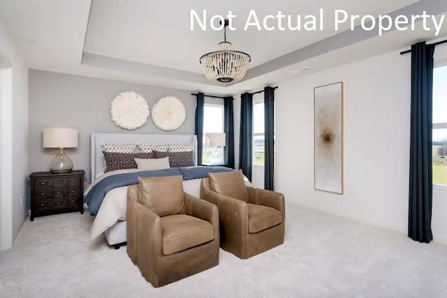carpeted bedroom featuring a chandelier and a raised ceiling