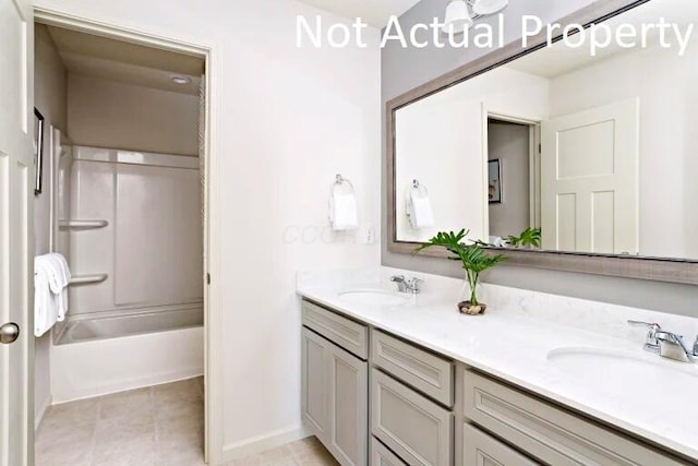 full bath with a sink, baseboards, tile patterned floors, and double vanity