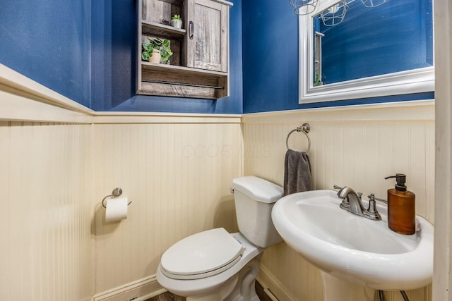 5392 Grandon Dr, Hilliard, OH 43026 - half bathroom featuring toilet, a wainscoted wall, and a sink