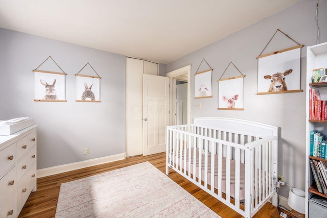 5392 Grandon Dr, Hilliard, OH 43026 - bedroom featuring wood finished floors, baseboards, and a crib