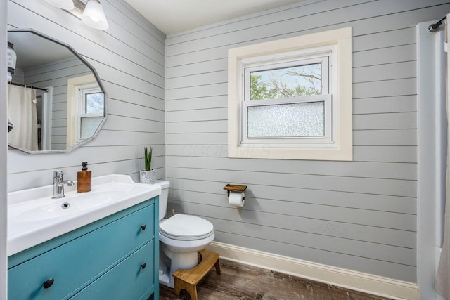 5392 Grandon Dr, Hilliard, OH 43026 - bathroom with healthy amount of natural light, wood finished floors, toilet, vanity, and wooden walls