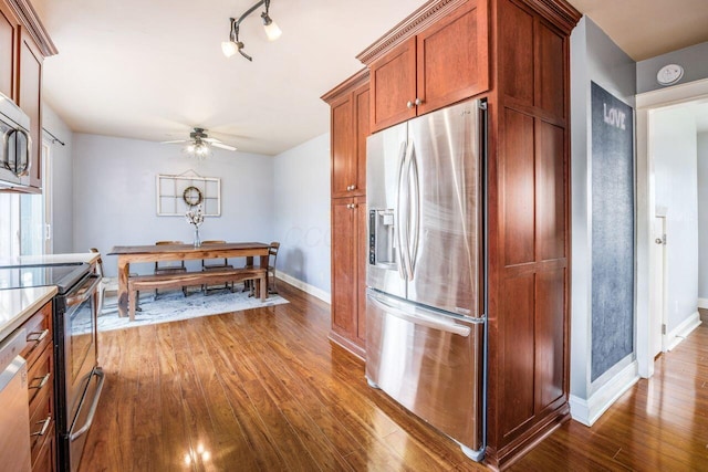 5392 Grandon Dr, Hilliard, OH 43026 - kitchen with appliances with stainless steel finishes, dark wood-type flooring, baseboards, a ceiling fan, and brown cabinetry