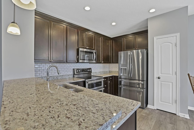 149 Broadmoore Blvd, Pataskala, OH 43062 - kitchen with light stone counters, a sink, dark brown cabinetry, and stainless steel appliances
