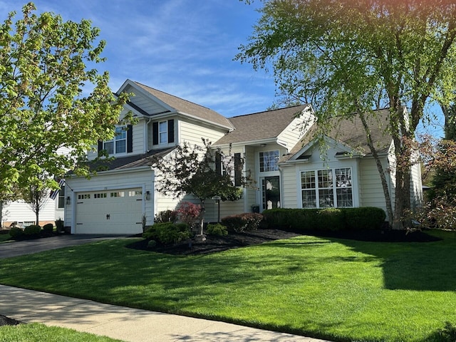 split level home featuring an attached garage, a front lawn, and aphalt driveway