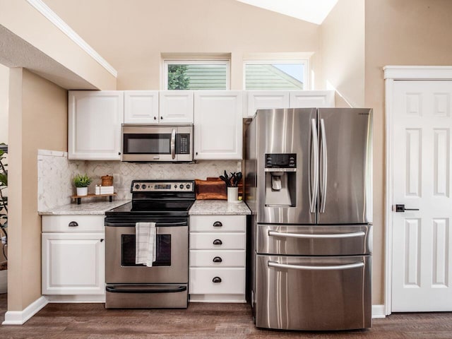 kitchen with a healthy amount of sunlight, dark wood-type flooring, white cabinetry, appliances with stainless steel finishes, and backsplash