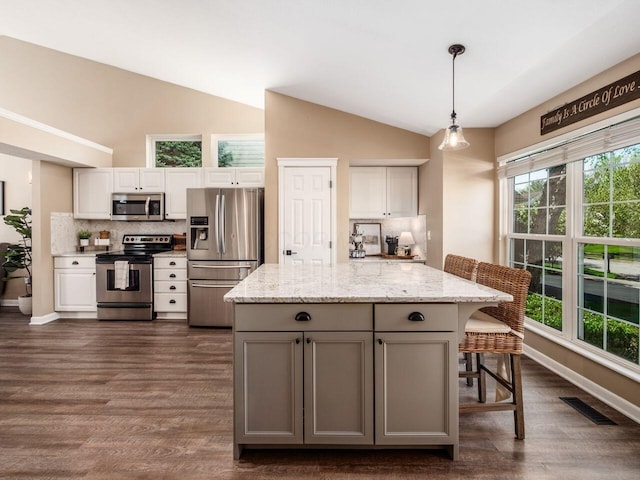 kitchen featuring dark wood-style flooring, appliances with stainless steel finishes, visible vents, and tasteful backsplash
