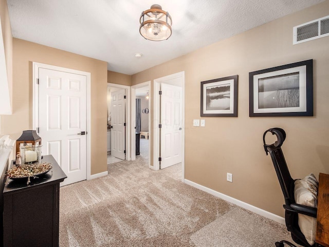 carpeted home office with visible vents and baseboards