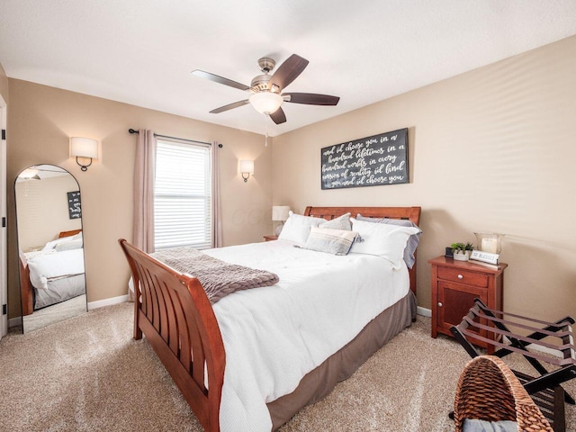 carpeted bedroom featuring baseboards and a ceiling fan