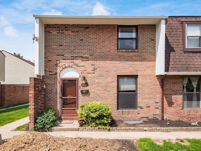 multi unit property with brick siding and roof with shingles