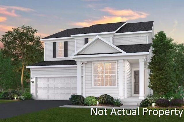 view of front of home featuring roof with shingles, an attached garage, and aphalt driveway