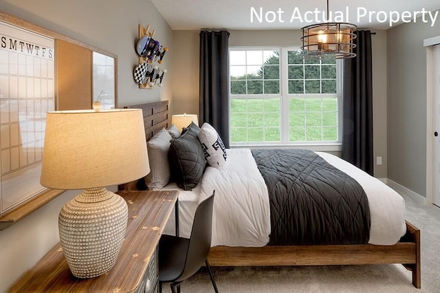 carpeted bedroom with baseboards and a notable chandelier