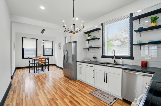 kitchen with open shelves, dark countertops, white cabinetry, a sink, and appliances with stainless steel finishes