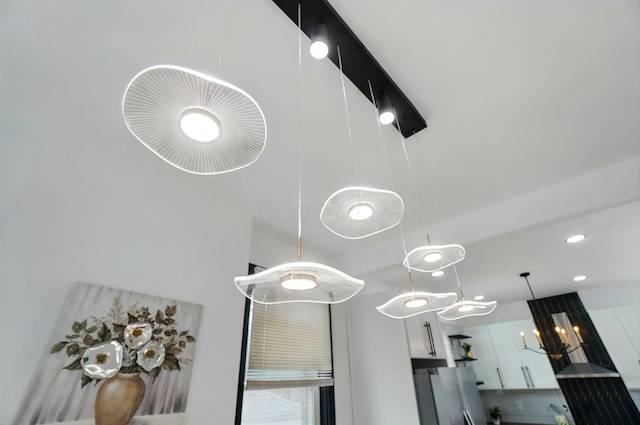 room details featuring hanging light fixtures and fridge