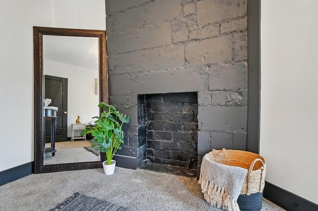 interior details with a fireplace with flush hearth and carpet