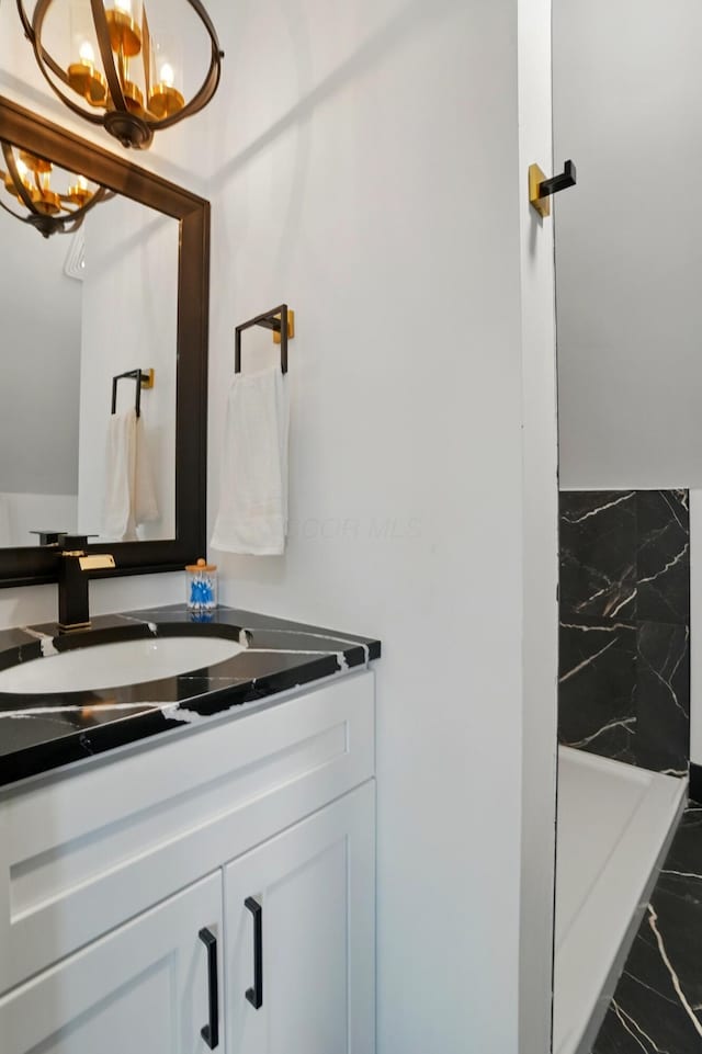 bathroom featuring vanity, marble finish floor, and a chandelier