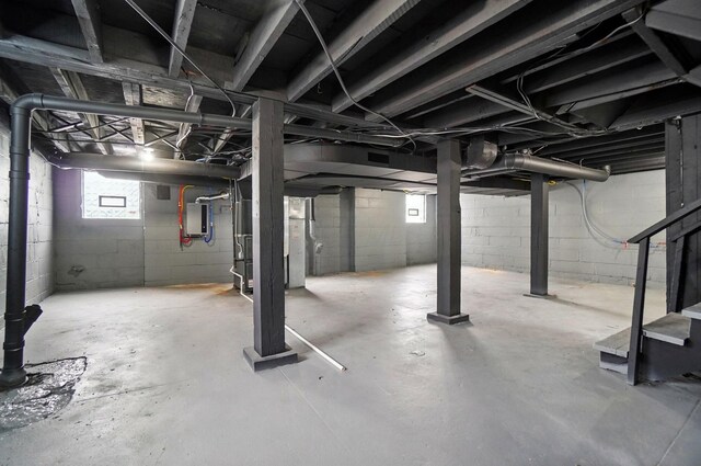 basement featuring stairs and electric panel