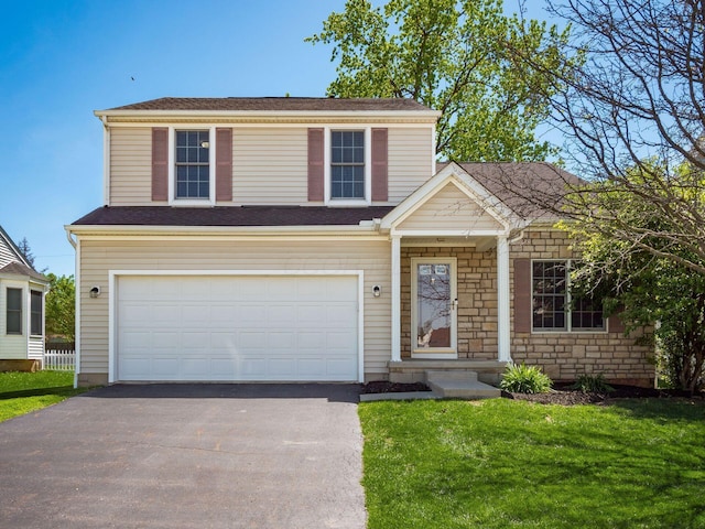traditional-style home with an attached garage, driveway, and a front yard