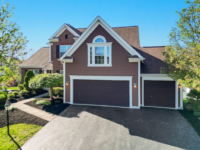 view of front of home with roof with shingles and aphalt driveway