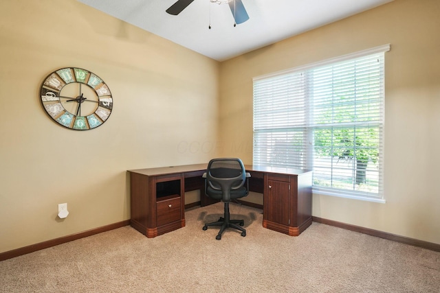 office area with a ceiling fan, baseboards, and light carpet