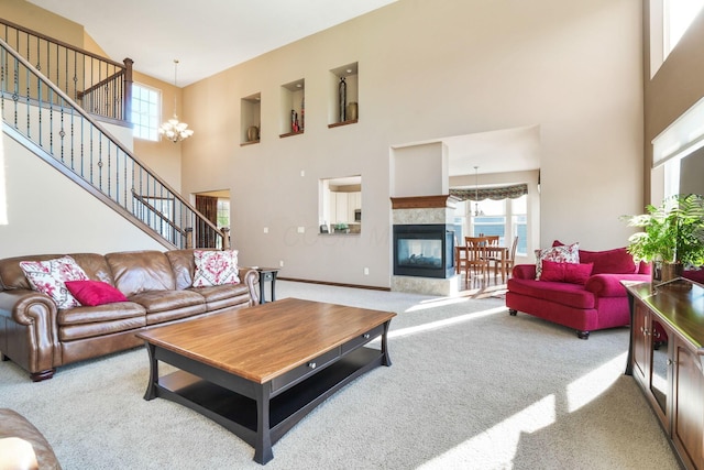 living room with carpet floors, a high ceiling, a multi sided fireplace, and stairway