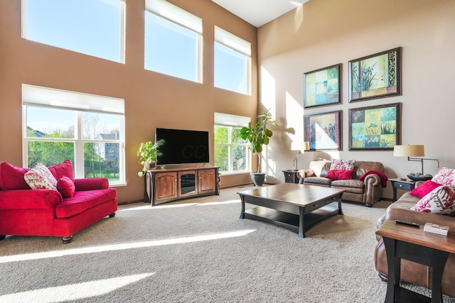 living area featuring carpet floors and a towering ceiling