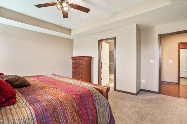 bedroom with baseboards, carpet, ceiling fan, and ensuite bathroom