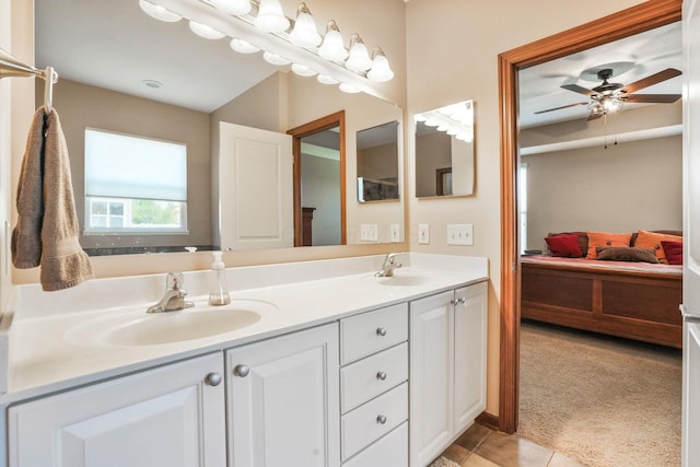ensuite bathroom with connected bathroom, ceiling fan, a sink, double vanity, and tile patterned floors