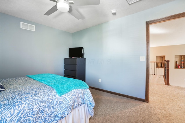 carpeted bedroom with a ceiling fan and visible vents