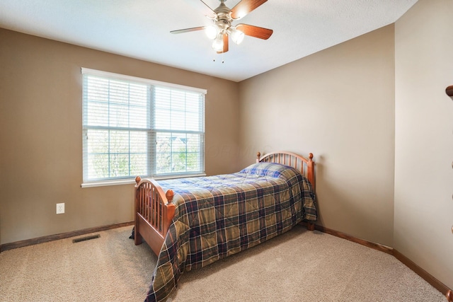 bedroom with a ceiling fan, baseboards, visible vents, and carpet