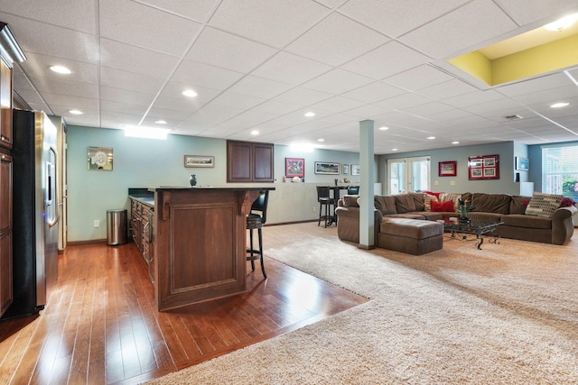 interior space featuring bar, baseboards, and light wood finished floors