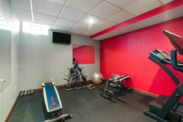 exercise room with baseboards, recessed lighting, and a paneled ceiling