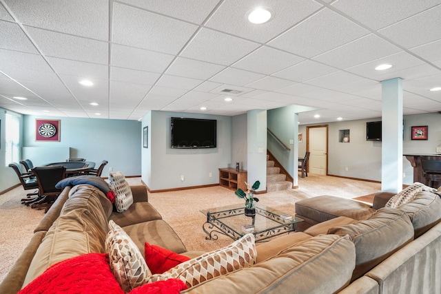 living area featuring baseboards, light colored carpet, and a paneled ceiling