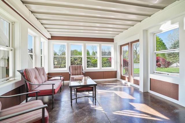 sunroom featuring plenty of natural light, baseboards, and concrete flooring