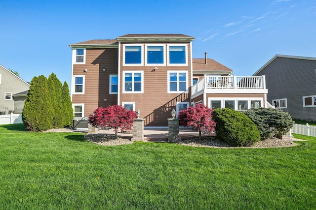 rear view of property featuring stairway, a lawn, fence, and roof with shingles