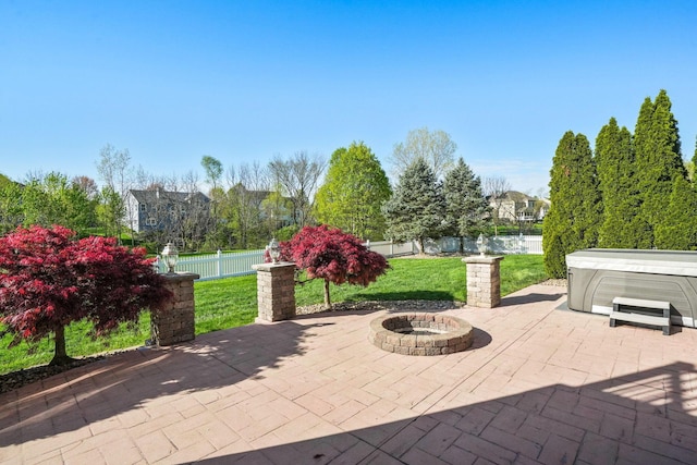 view of patio featuring fence, a hot tub, and an outdoor fire pit
