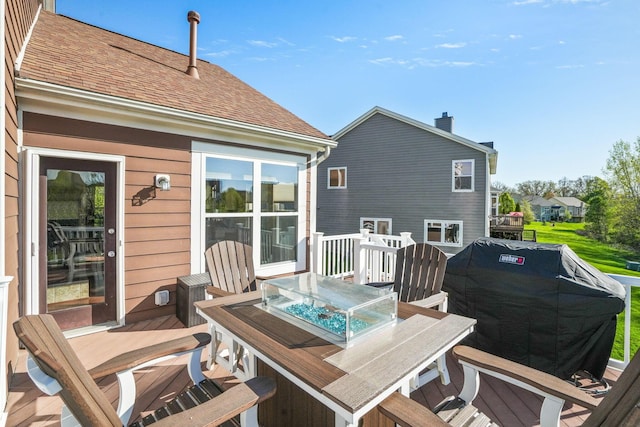 wooden terrace featuring area for grilling and outdoor dining space