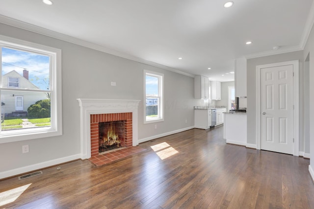 unfurnished living room with plenty of natural light, ornamental molding, and visible vents