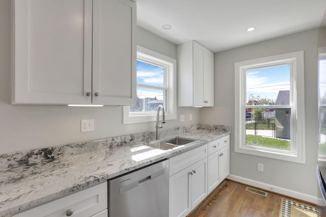 kitchen featuring a sink, dishwasher, white cabinetry, wood finished floors, and visible vents