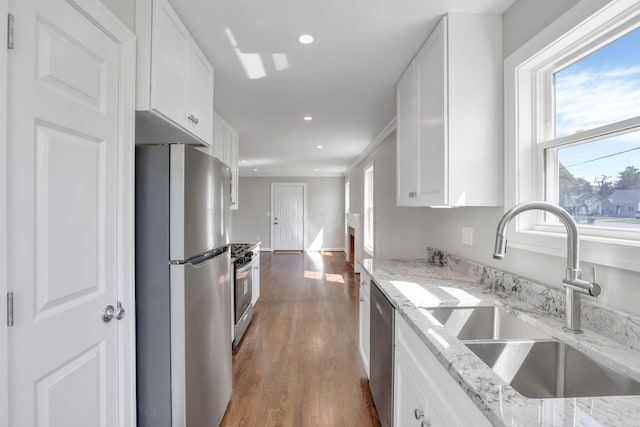 kitchen featuring white cabinets, stainless steel appliances, a healthy amount of sunlight, and a sink