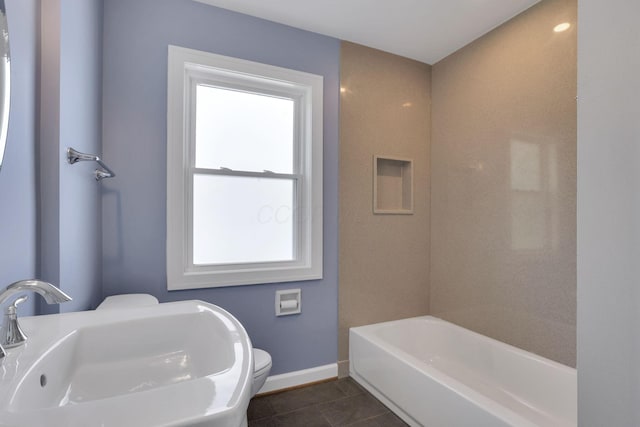 bathroom featuring toilet, baseboards, plenty of natural light, and a sink