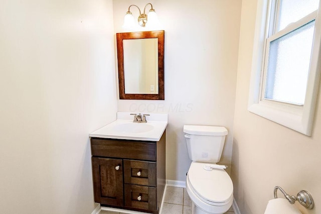 half bath with vanity, baseboards, tile patterned floors, and toilet