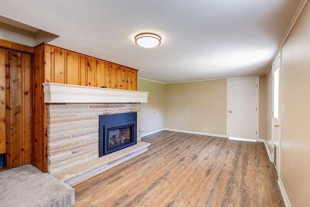 living room with baseboards, a glass covered fireplace, and wood finished floors