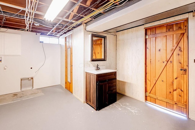 basement with a sink and wooden walls